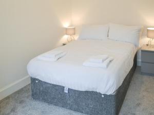 Un dormitorio con una cama con dos toallas encima. en Forest Close, en Forest Hall