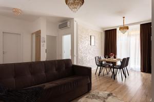 a living room with a couch and a table at Sika Regal Apartment Arad - private garden & parking - self check-in in Arad