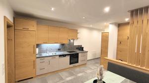 a kitchen with wooden cabinets and a sink at Auszeit Appartement Lesachtal in Liesing