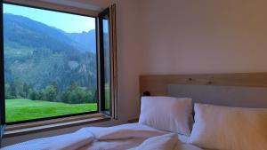 a bedroom with a bed and a large window at Auszeit Appartement Lesachtal in Liesing +18 photos