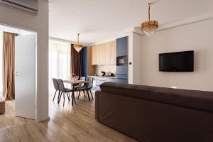 a living room with a kitchen and a dining room at Sika Regal Apartment Arad - private garden & parking - self check-in in Arad