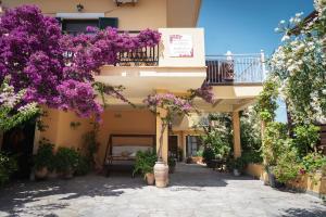 a building with purple flowers and a balcony at Kontis Apt 1 in Pelekas