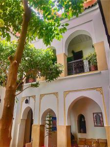 un edificio con un albero di fronte di Riad ABBASSIA Marrakech Premiere - Authentic Medina Experience a Marrakech