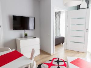 a white room with a table and a tv on a wall at Apartament Międzyzdroje Horyzont in Międzyzdroje