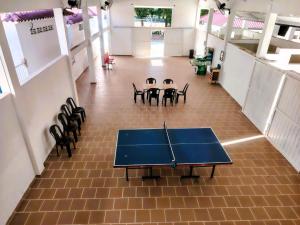 a ping pong table in a room with chairs at Acaymas Club in Ricaurte