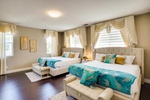 1 Schlafzimmer mit 2 Betten, einem Sofa und Fenstern in der Unterkunft 3 Mi to Disneyland Home with Hot Tub and Game Room in Anaheim + 32 Fotos