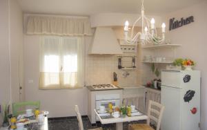 a small kitchen with a white refrigerator and a table at Il Linchetto in Lucca