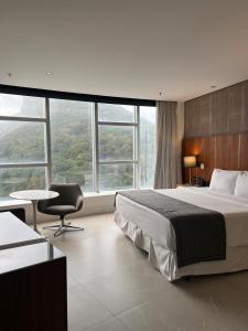 a hotel room with a bed and a chair and windows at Hotel Nacional in Rio de Janeiro