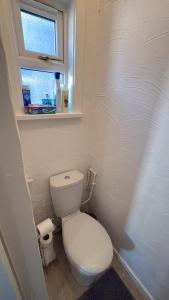 a small bathroom with a toilet and a window at Blackpool Pleasure Beach whole Holiday Home! in Blackpool +6 photos