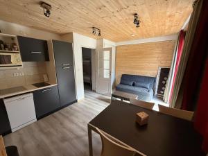 a kitchen and a living room with a blue couch at Studio 4 pers in Les Orres