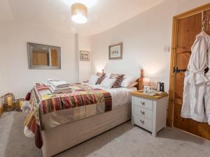 a bedroom with a bed and a wooden door at Harpers Cottage in Barrowford +20 photos