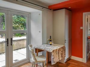 une salle à manger avec une table et une fenêtre dans l'établissement Maines Farm Cottage, à Chirnside