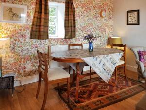 une salle à manger avec une table et des chaises dans l'établissement Maines Farm Cottage, à Chirnside