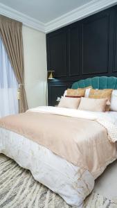 a bedroom with a large bed with a black headboard at Tériya House in Dakar