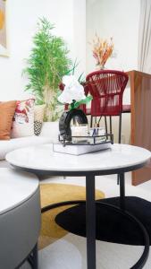 a white coffee table in a living room with red chairs at Tériya House in Dakar