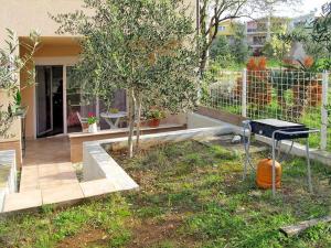 a grill in a yard next to a house at Apartment Vivoda in Štinjan