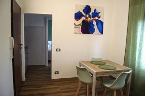 a dining room table with chairs and a painting on the wall at Iris House in Ferrara