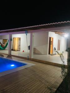 a villa with a swimming pool at night at Casa Portal da Lagoinha in Tigre