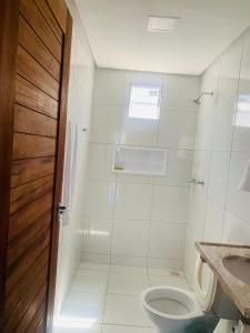 a bathroom with a toilet and a sink at Casa Portal da Lagoinha in Tigre