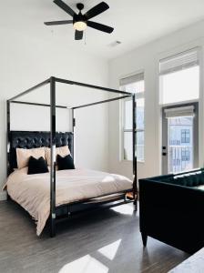 a bedroom with a black canopy bed with a ceiling fan at Upper Westside Jewel in Atlanta