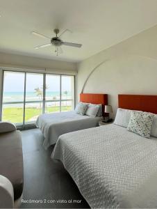 2 letti in una camera da letto con vista sull'oceano di Grand Suite Diamante Copan 301 ad Acapulco