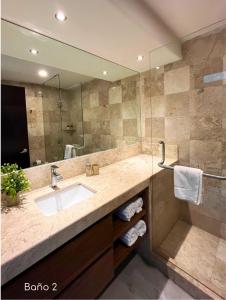 un bagno con lavandino e specchio di Grand Suite Diamante Copan 301 ad Acapulco