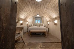 a bedroom with a large bed in a stone room at The Lantern in Bourton on the Water