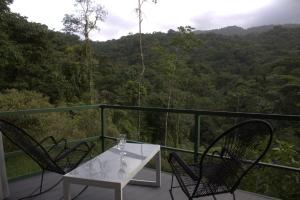 een witte tafel en stoelen op een balkon met uitzicht bij Village Río Celeste, Eco Lodge and Tours in Rio Celeste +92 foto's
