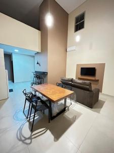 een woonkamer met een tafel en een bank bij Studio Bougainville Apart in Conceição do Mato Dentro