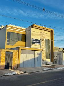 a building with two garage doors on a street at Studio Bougainville Apart in Conceição do Mato Dentro