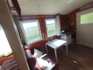 a small room with a table and two windows at Reichsbahnwagon Sandau in Sandau