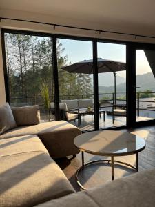 a living room with couches and a table with an umbrella at La Casa Cottage in Jajce