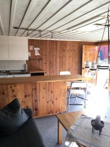a kitchen with wooden walls and a table and chairs at Stuga på gård i Böda socken in Löttorp