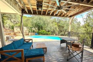 un patio con tavolo e sedie e una piscina di Mountain Trail Retreat ad Austin