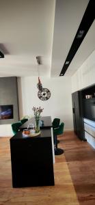 a living room with a black table and green chairs at Apartament na Mazurach in Ełk