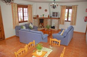 a living room with blue furniture and a fireplace at El Mirador in Iznájar