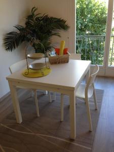 a white table with a plant and a basket on it at Bel appartement de Gill centre ville Nice in Nice