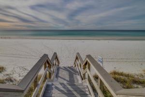 a staircase leading to a sandy beach with the ocean at Bahia #4110 in Destin +22 photos