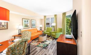 a living room with a couch and chairs in a hotel room at Mizner Place at Weston Town Center, Fort Lauderdale in Weston