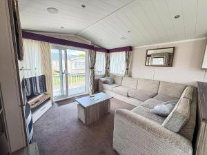a living room with a couch and a tv at Stunning 6 Berth Caravan, Close To The Beach In Suffolk Ref 68067Cr in Lowestoft
