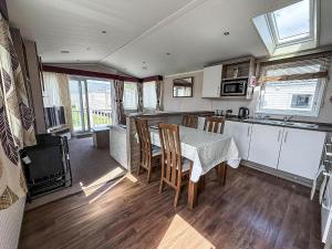 a kitchen and dining room with a table and chairs at Stunning 6 Berth Caravan, Close To The Beach In Suffolk Ref 68067Cr in Lowestoft