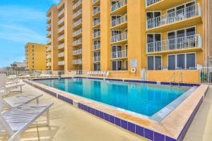 a swimming pool in front of a building at Oceania Plaza 509 in New Smyrna Beach
