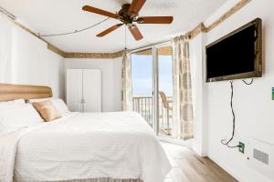 a bedroom with a bed and a flat screen tv at Oceania Plaza 509 in New Smyrna Beach +27 photos