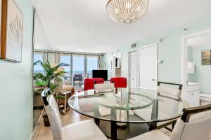 Un comedor con una mesa de cristal y sillas. en Oceania Plaza 204, en New Smyrna Beach