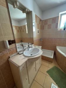 a bathroom with a sink and a tub and a mirror at Privat vila 303 in Martin +21 photos