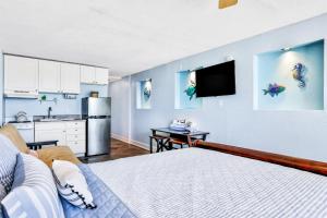a bedroom with a large bed and a kitchen at Atlantic Skies in Daytona Beach Shores