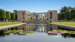 un edificio con flores en el agua delante de él en Camping Colleville-sur-Mer, en Colleville-sur-Mer