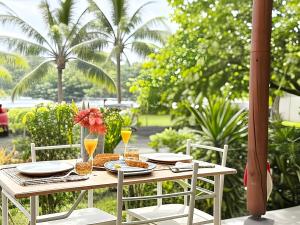 einen Tisch mit Speisen und Getränken auf einer Terrasse in der Unterkunft Charming beachfront studio in Bora Bora + 48 Fotos