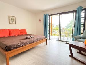 ein Schlafzimmer mit einem Bett und einer Glasschiebetür in der Unterkunft Charming beachfront studio in Bora Bora