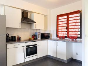 eine Küche mit weißen Schränken und einem Fenster in der Unterkunft Charming beachfront studio in Bora Bora